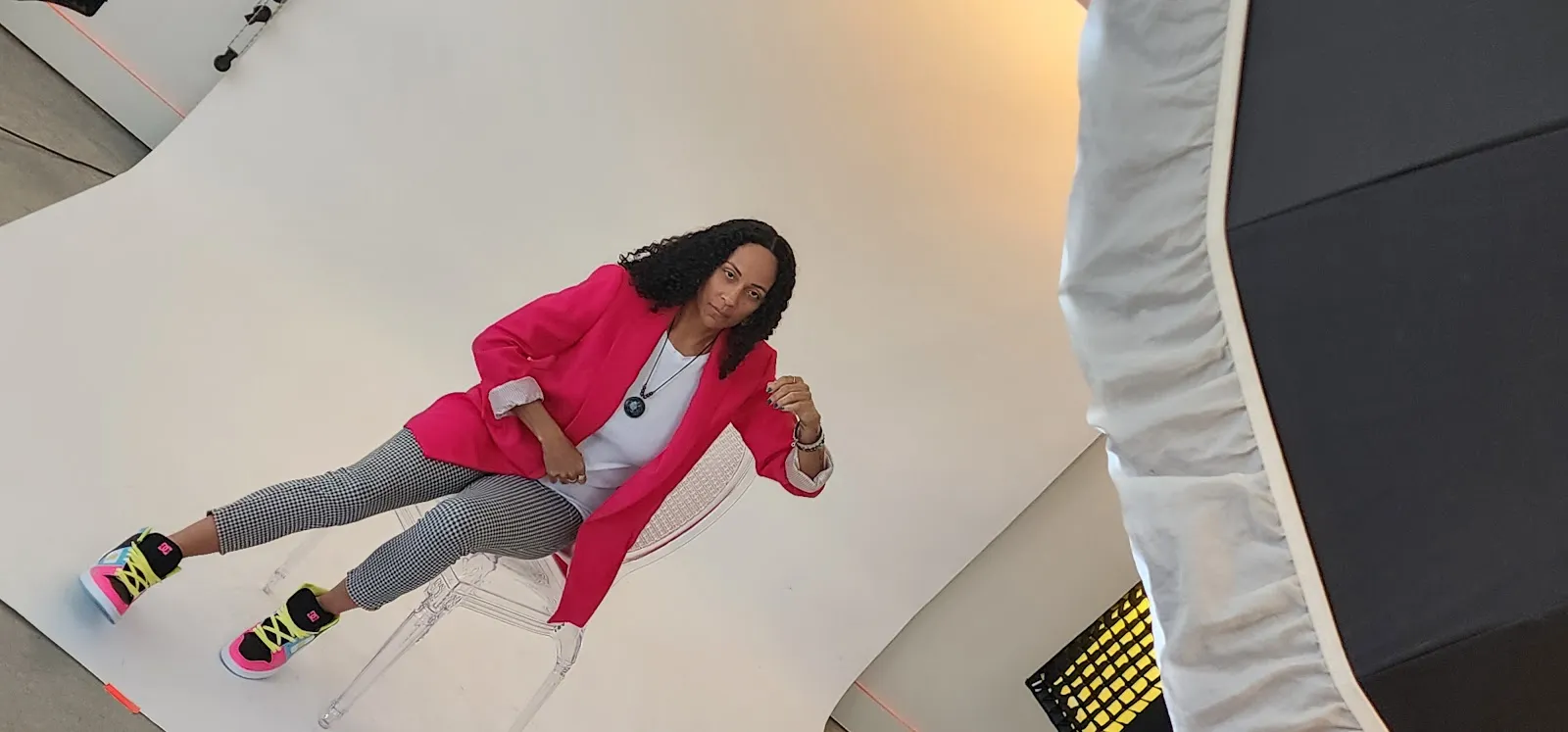 Yoshee sitting in a pink blazer in the studio